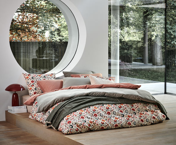 een bed met bloemen print dekbedovertrek en een groen en roze dekbedovertrek ene en groen plaid